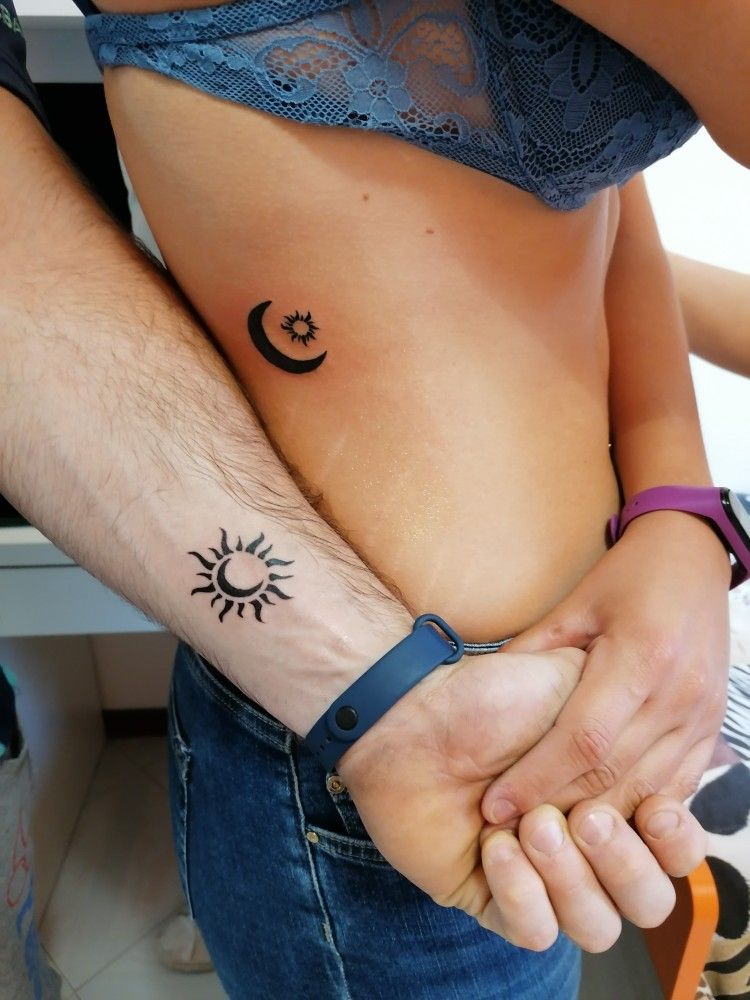 Bold black sun and moon couple tattoos, one on a forearm and one on the ribs