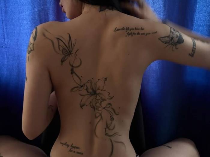Soft shaded butterfly and flower tattoo on the back with small script lines