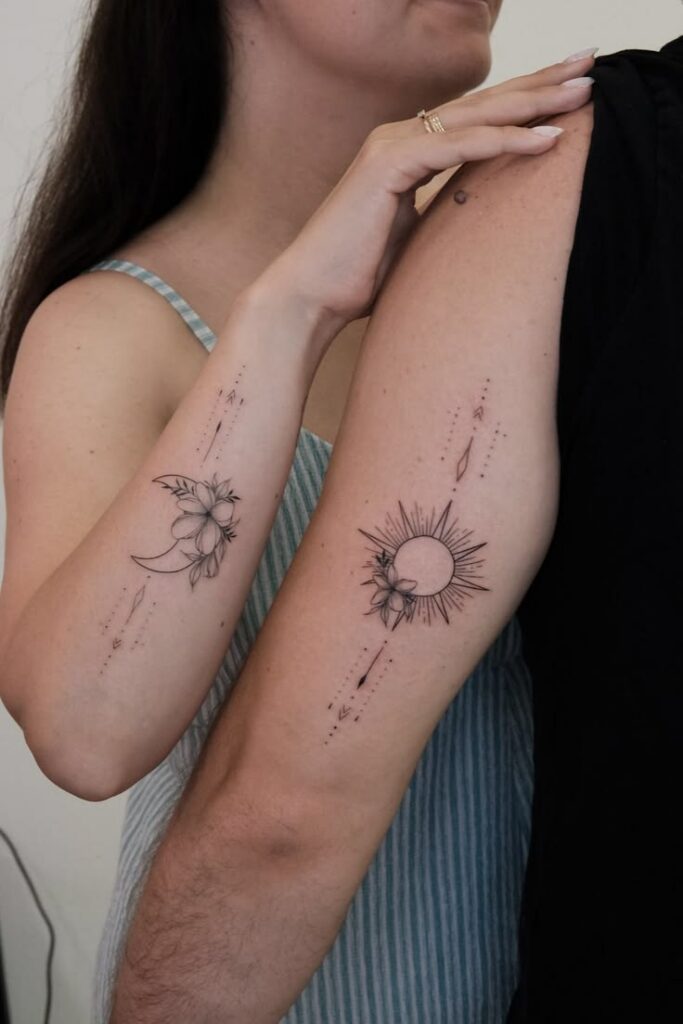 Floral sun and moon matching forearm tattoos with arrows and dotted lines on two people