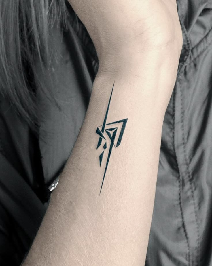 Black and white photo of a geometric abstract lightning tattoo on the wrist and forearm