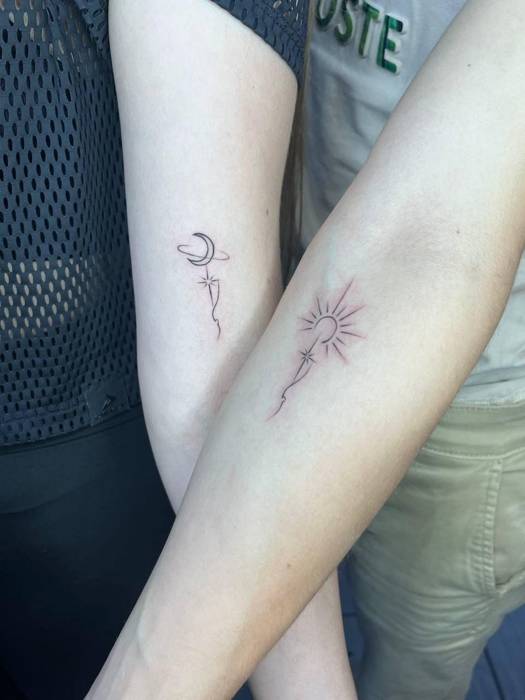 Matching fine-line moon and sun tattoos with small stars on two forearms