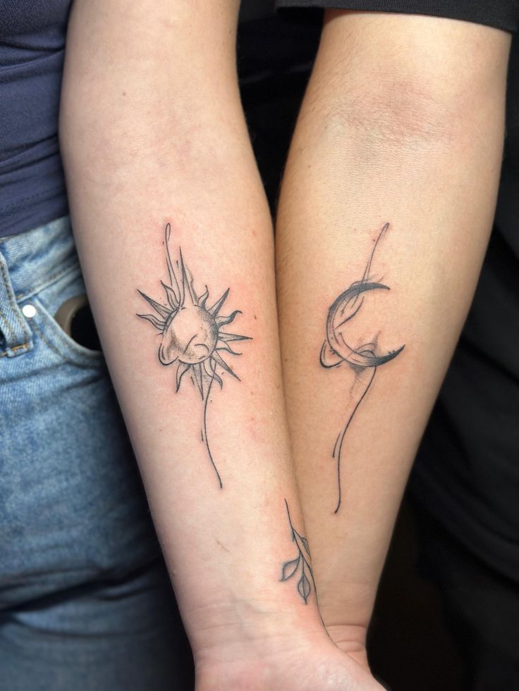 Matching sketch-style sun and crescent moon tattoos with a small leaf on two forearms