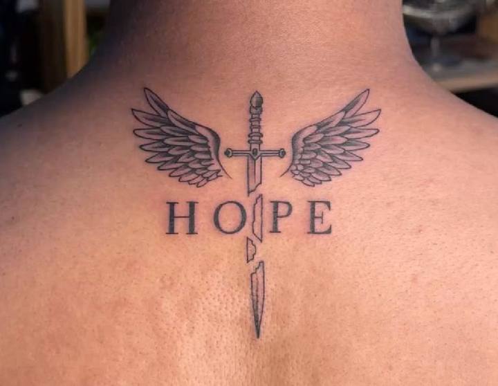 Winged sword with the word HOPE tattooed on the back of the neck