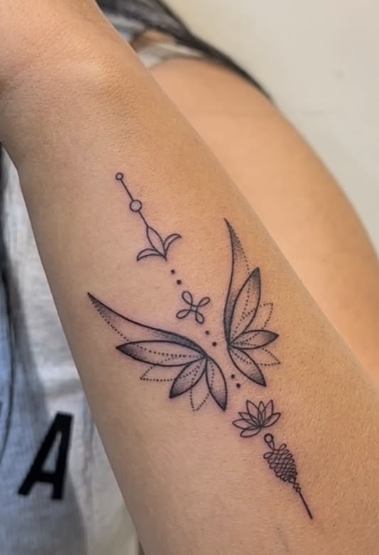 Lotus flower above a crescent moon and unalome on the inner forearm