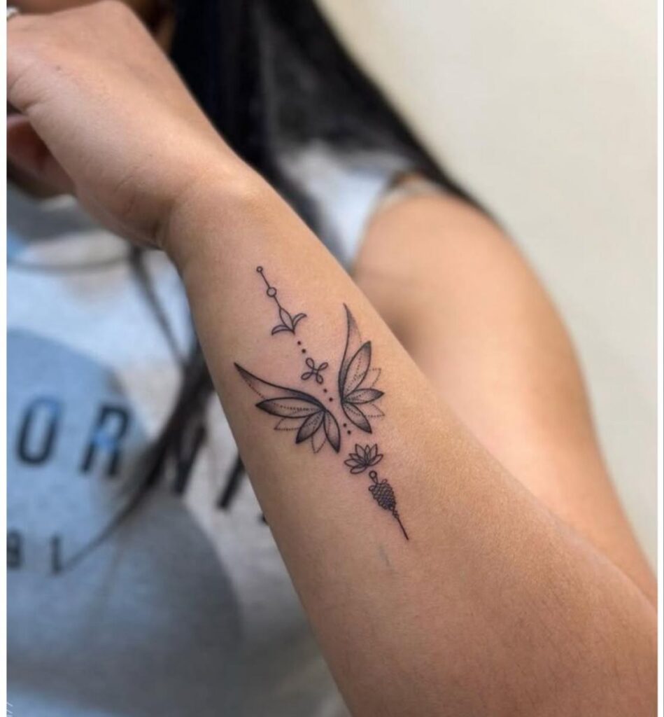Dotwork lotus petal wings with a small lotus and ornament on the forearm